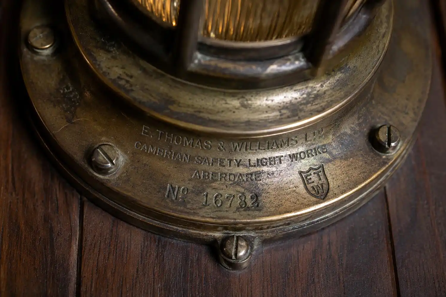 Maker stamp on vintage ship passageway light backplate showing salt patina