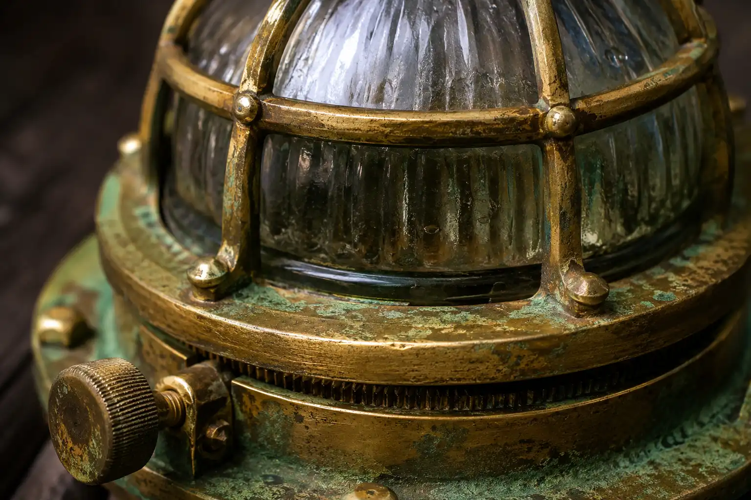 Close up of an antique brass deck light with domed glass, cage, and screw ring, salvaged in Bangladesh