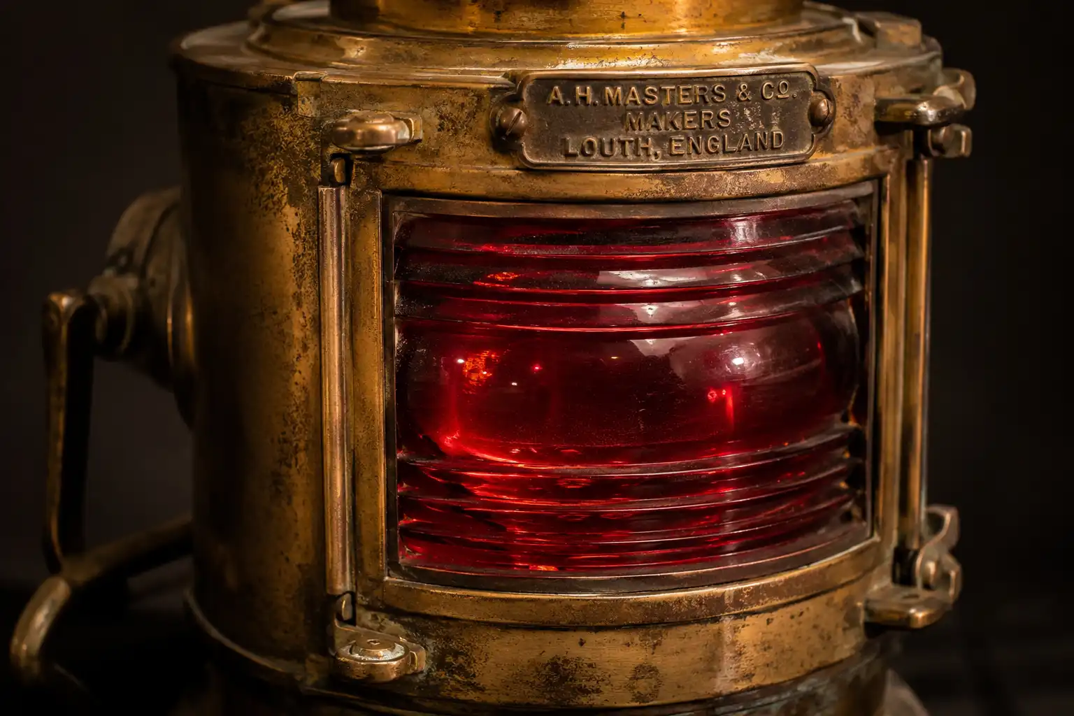 Restored brass port ship light with a red glass lens from Marine Salvage & Antiques in Bangladesh