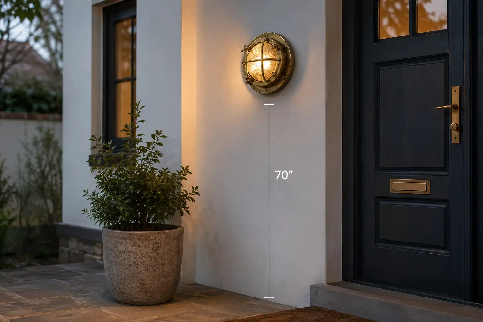 Brass bulkhead light mounted beside a front door at the proper height above the entryway