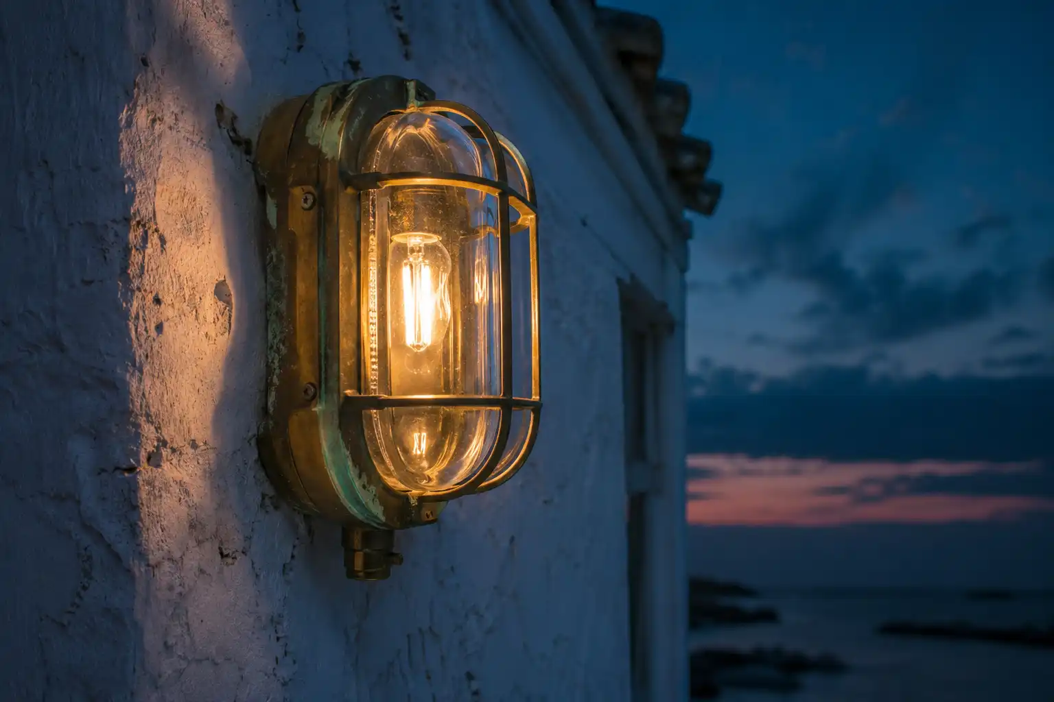 Restored ship bulkhead light from Bangladesh glowing warm on a weathered coastal wall at dusk